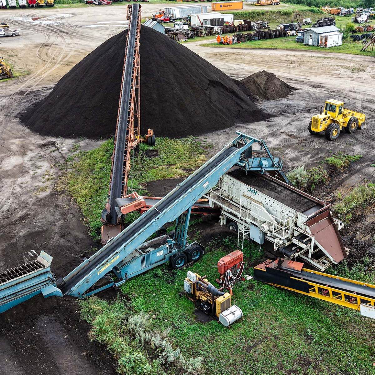 Conveyor screening rock and roots out of black dirt at the Storlie pit