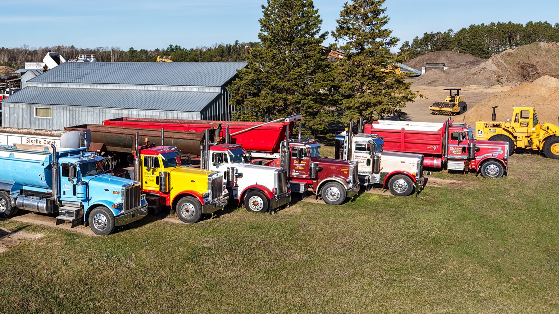Storlie dump trucks and heavy equipment lined up at the Highway 2 yard