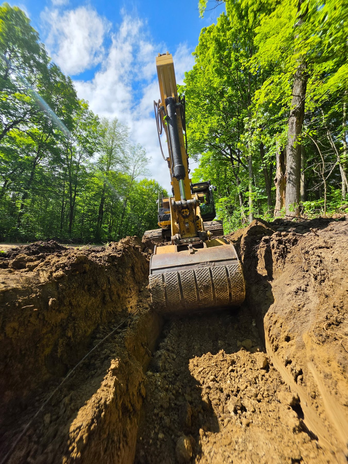 Excavator bucket working inside a deep excavation