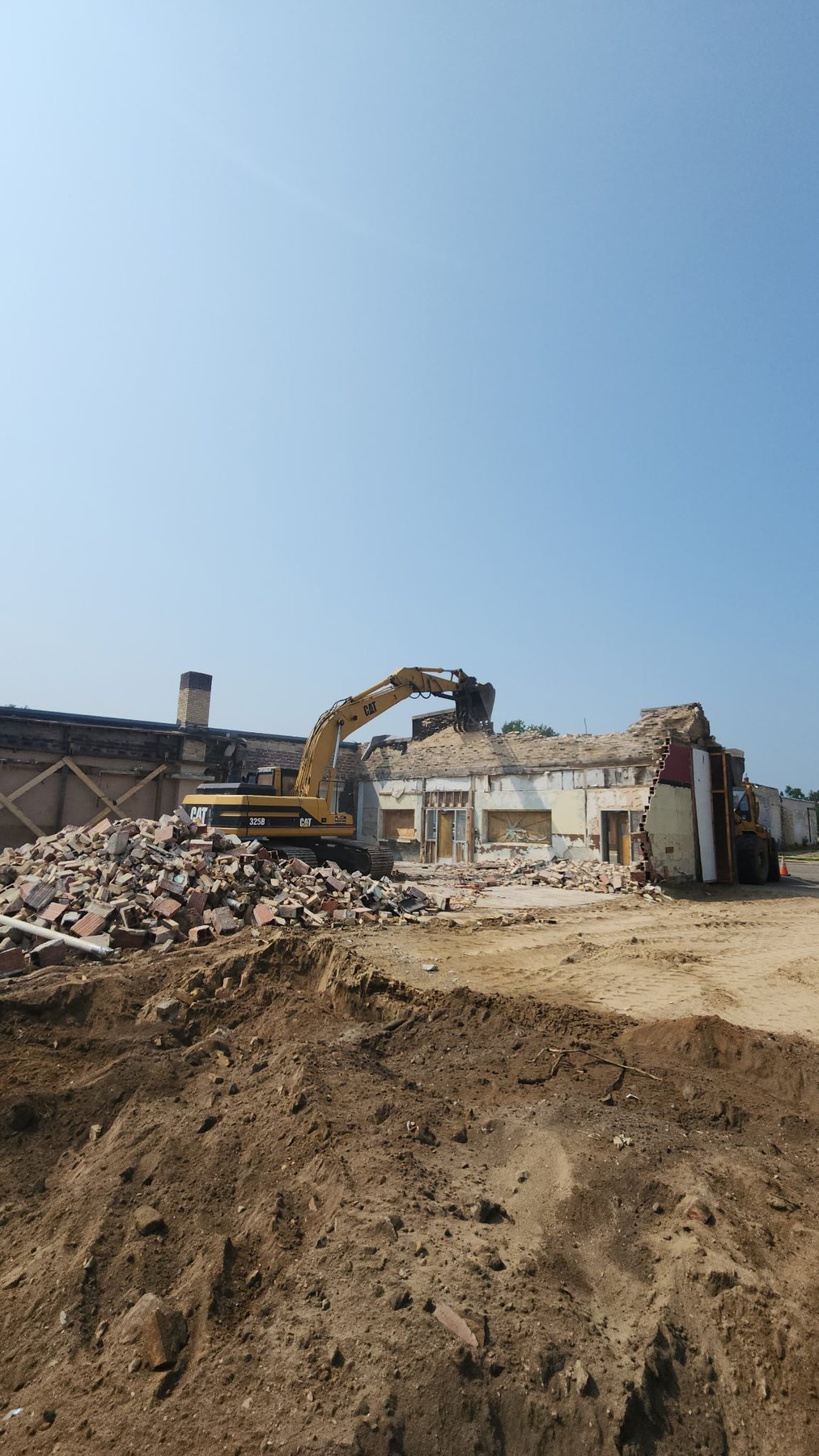 Storlie excavator taking down a masonry building