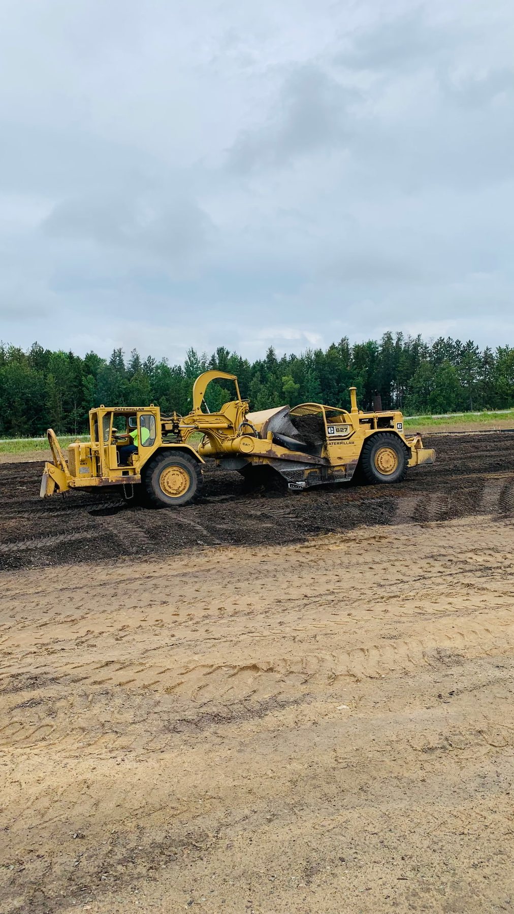 Earthmoving scrapers shaping a large work site