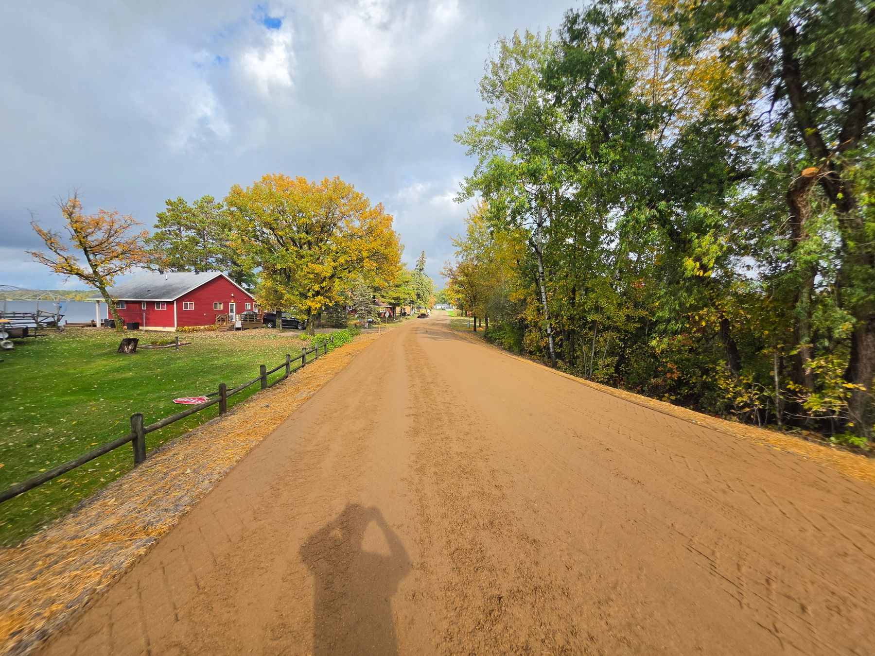 Rebuilt gravel road running past a red barn