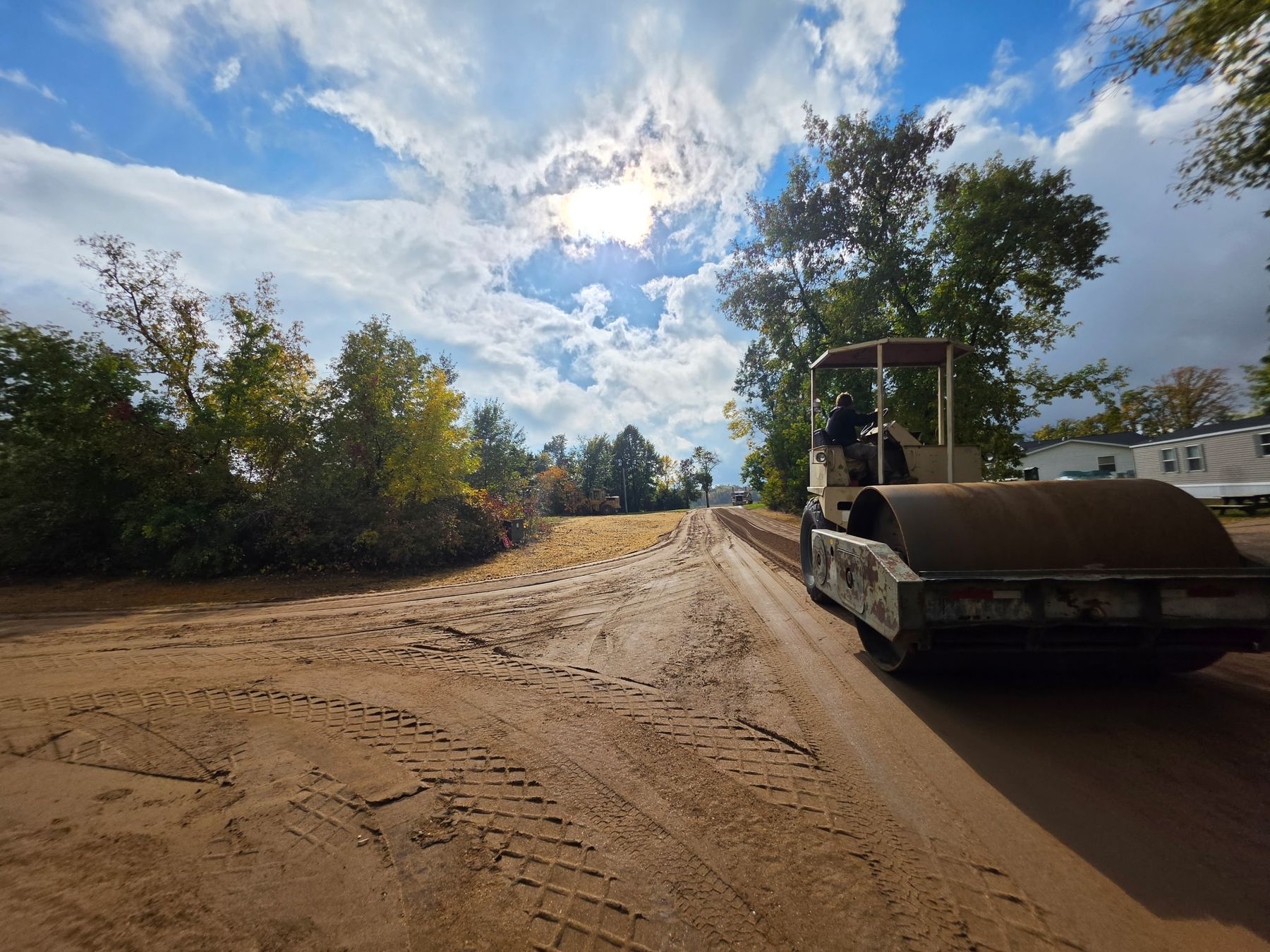 Roller compacting a rebuilt gravel road