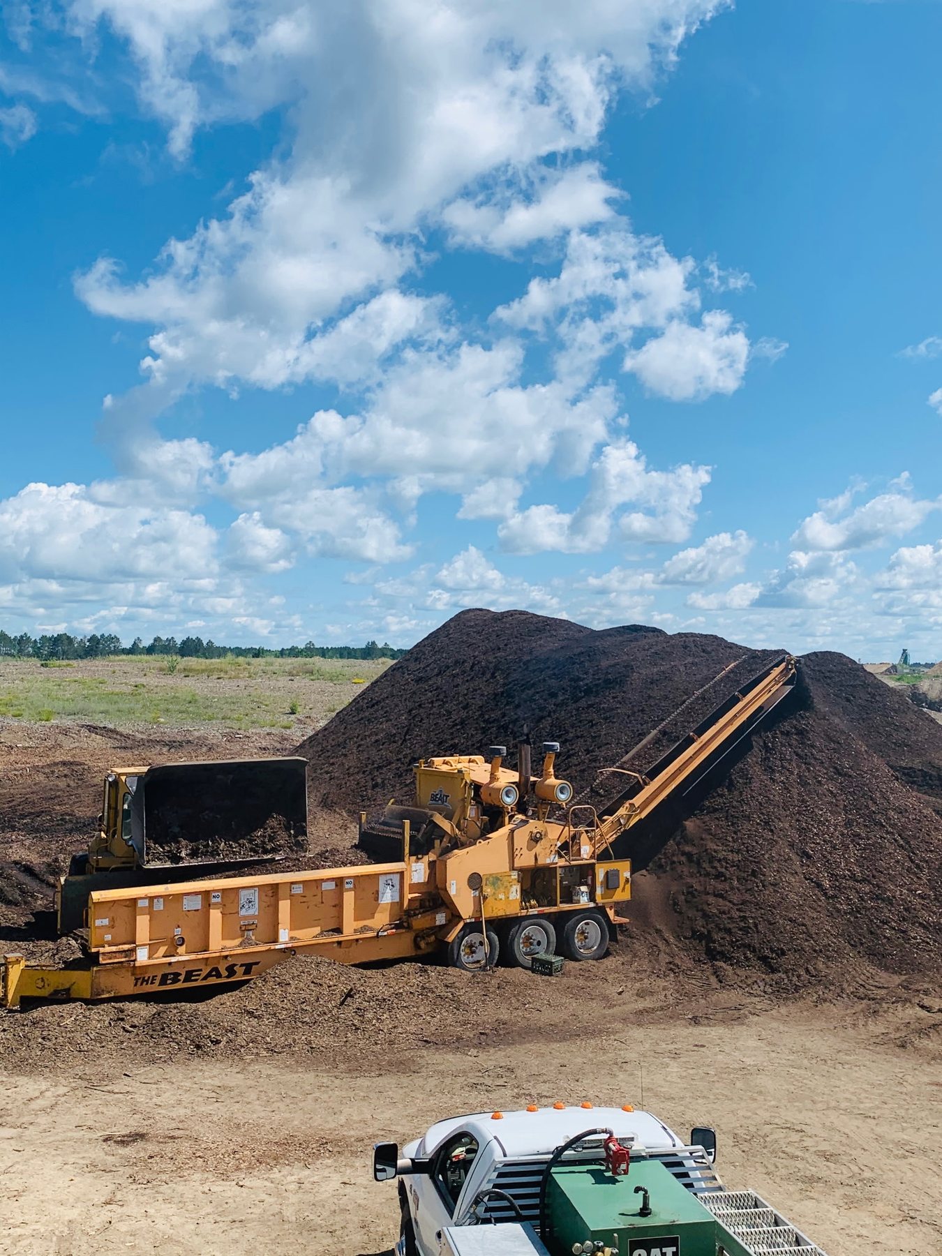 Aggregate screening equipment beside a large stockpile