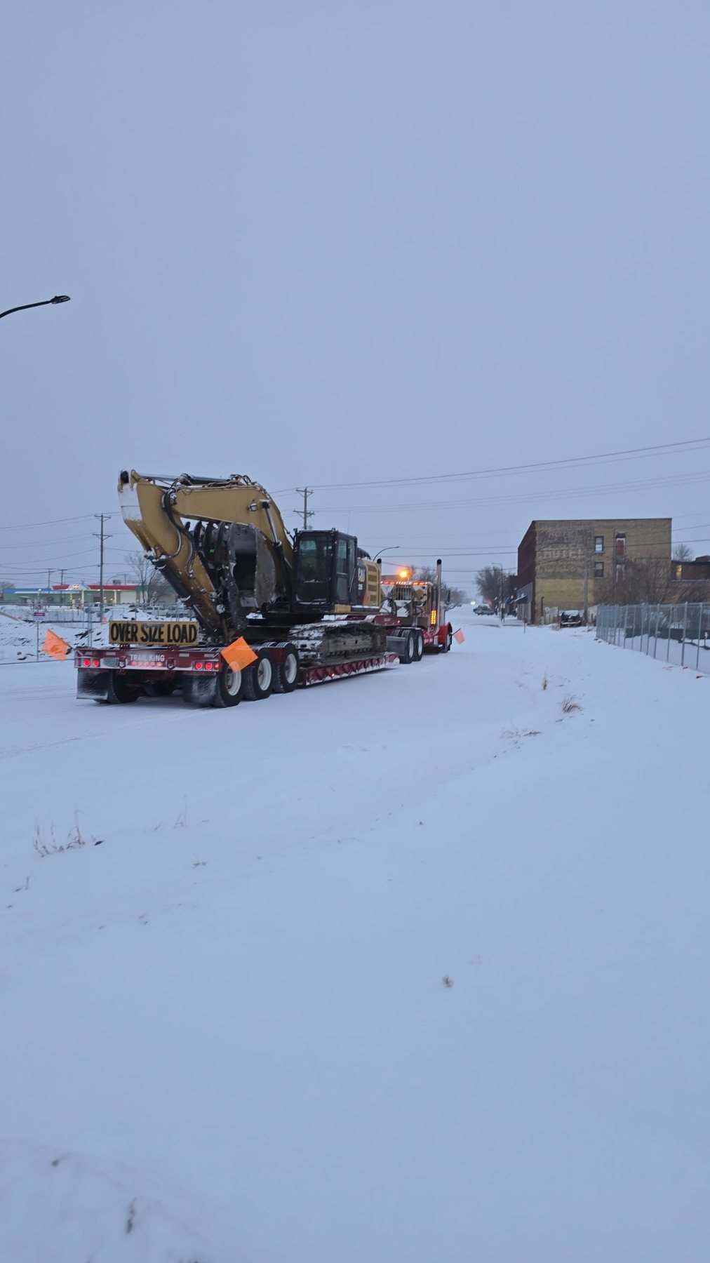 Storlie truck hauling heavy equipment in winter