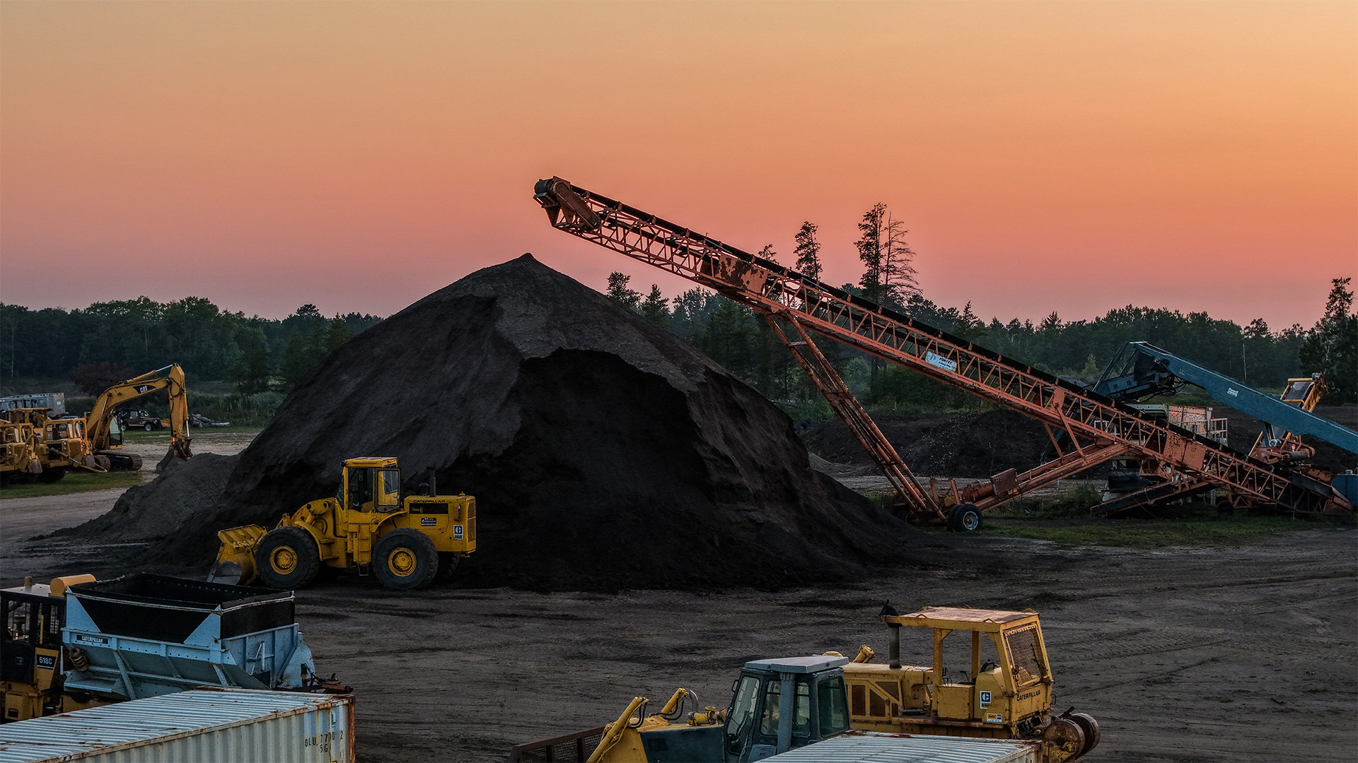 Storlie screening plant, aggregate stockpile, and equipment at sunset
